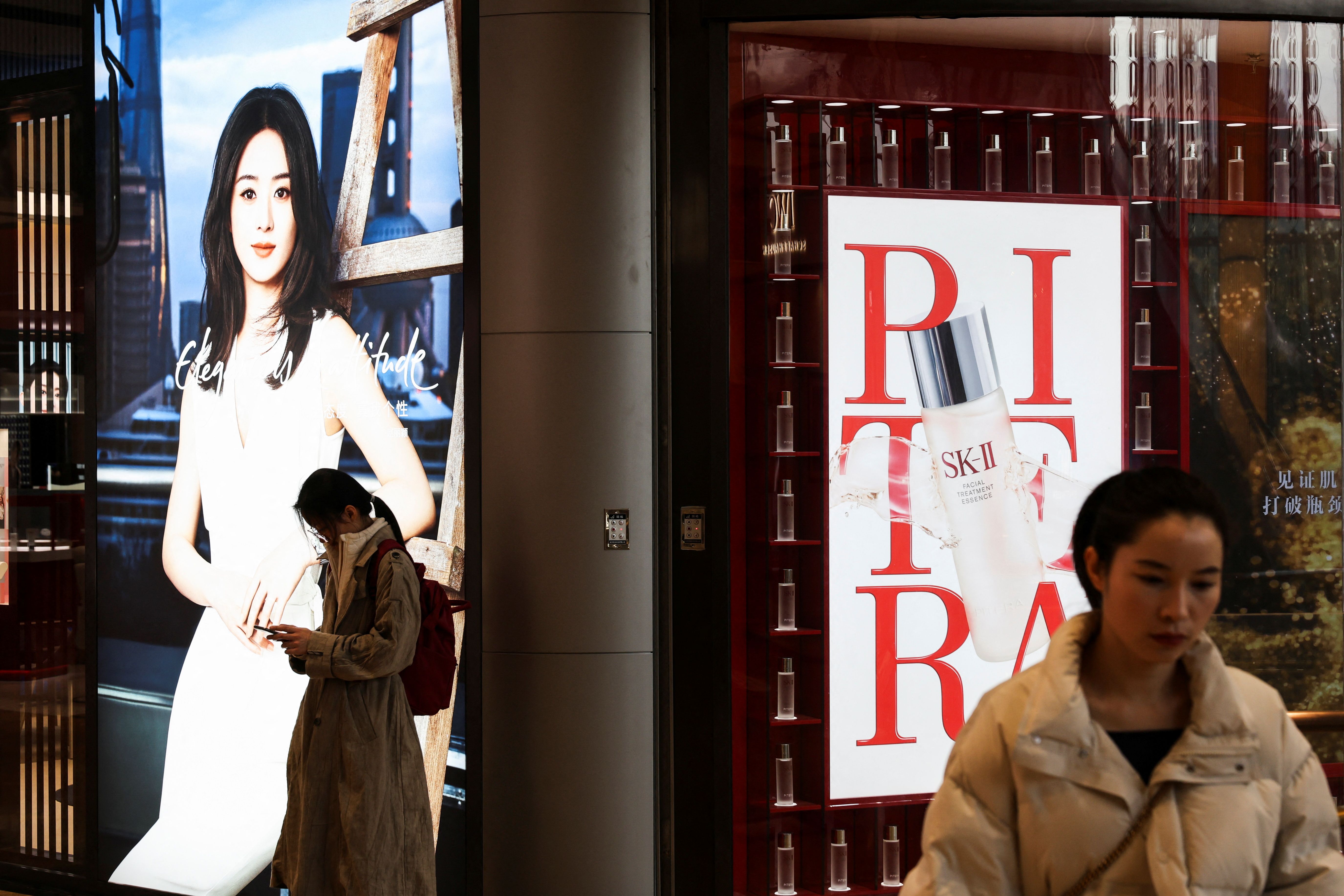A person checks her smartphone in the New World City shopping mall, ahead of the opening of the National People’s Congress (NPC), in Shanghai, China