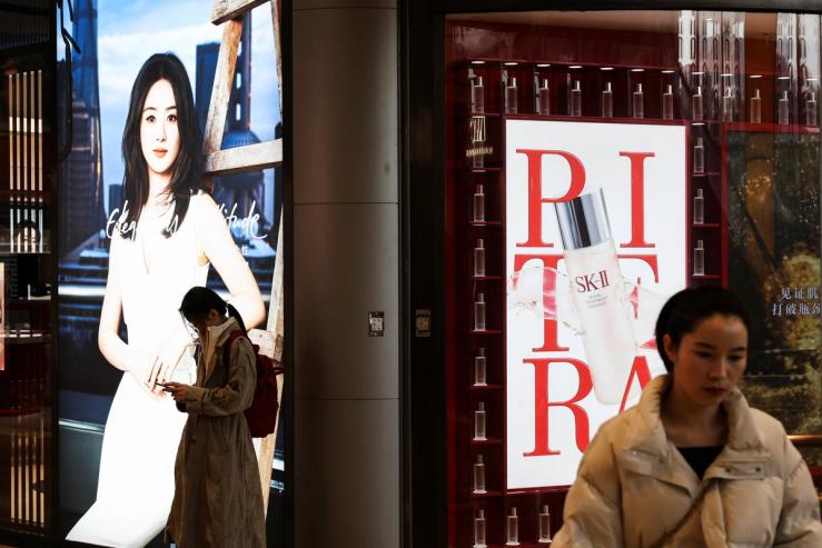 A person checks her smartphone in the New World City shopping mall, ahead of the opening of the National People’s Congress (NPC), in Shanghai, China