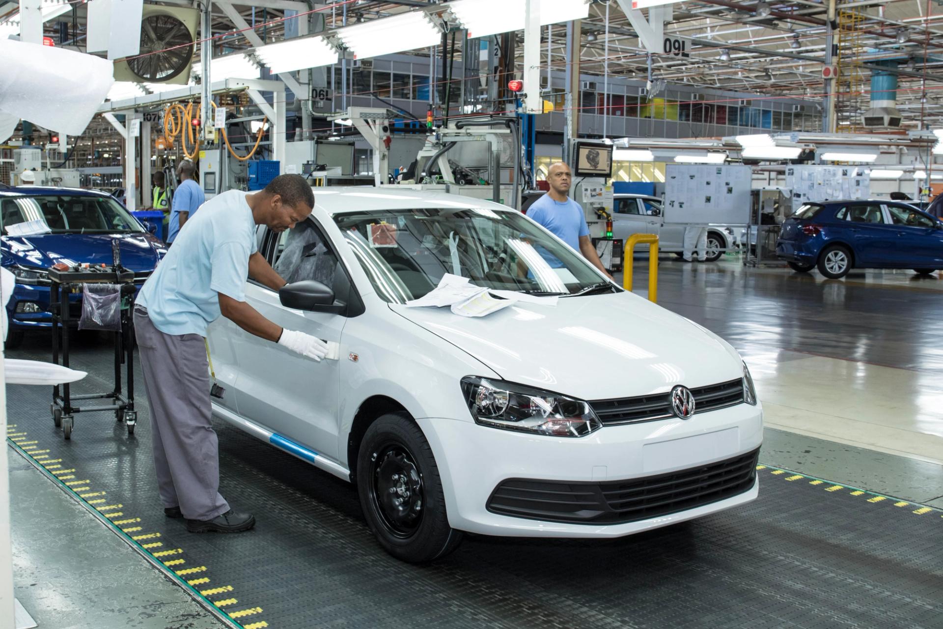 Workers at an automotive manufacturing plant in South Africa work on a vehicle.