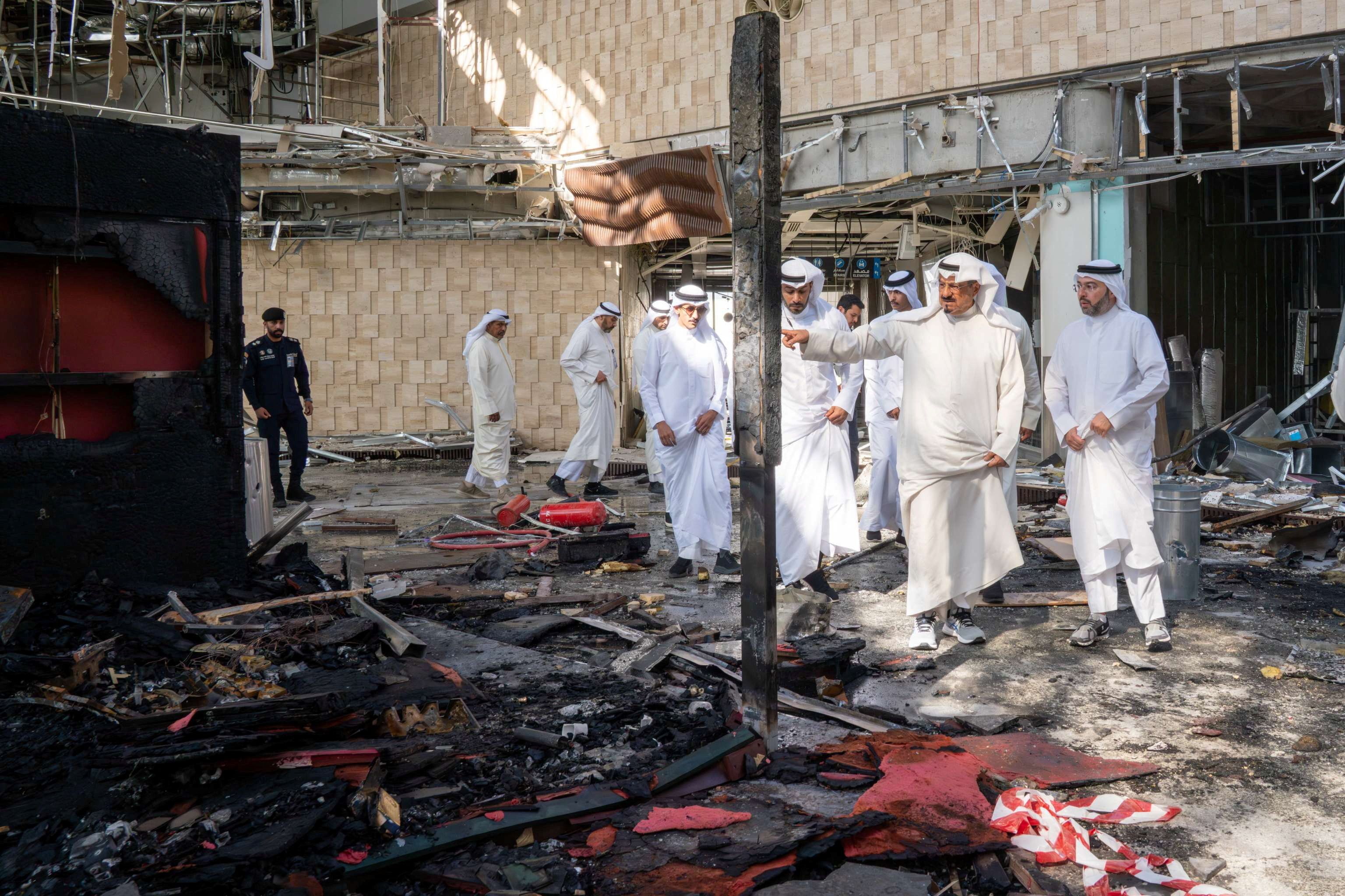 Kuwaiti officials inspect damage inside a terminal at Kuwait International Airport