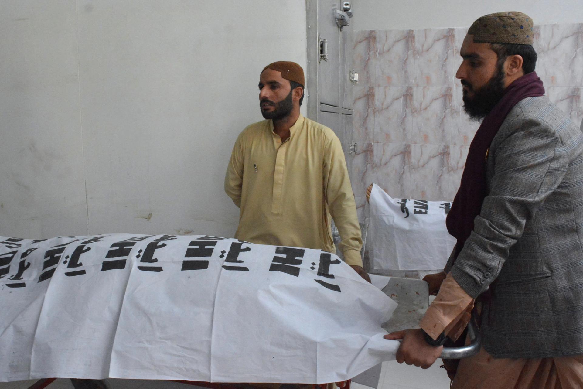 Men stand near covered bodies of victims, who were killed in a blast in Mastung, in hospital in Quetta, Pakistan September 29, 2023. REUTERS/Stringer