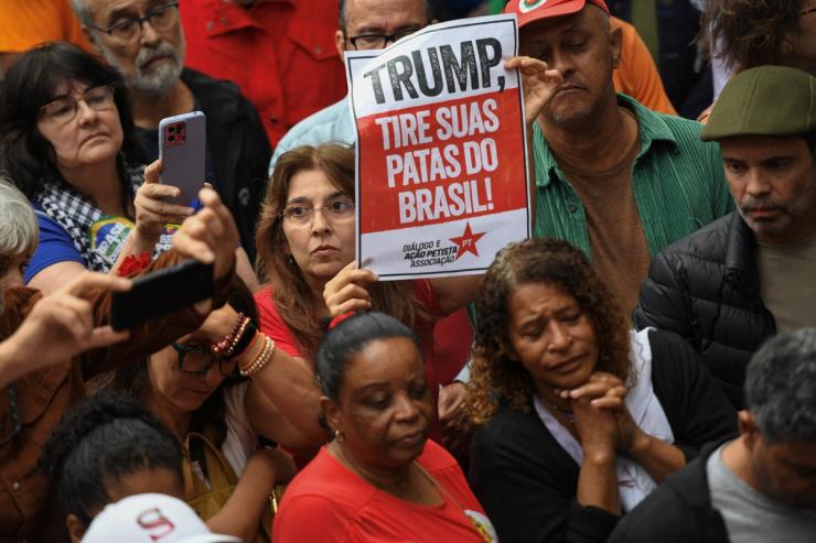 A protester holds a sign that reads “Trump, Get Your Paws Off Brazil.”