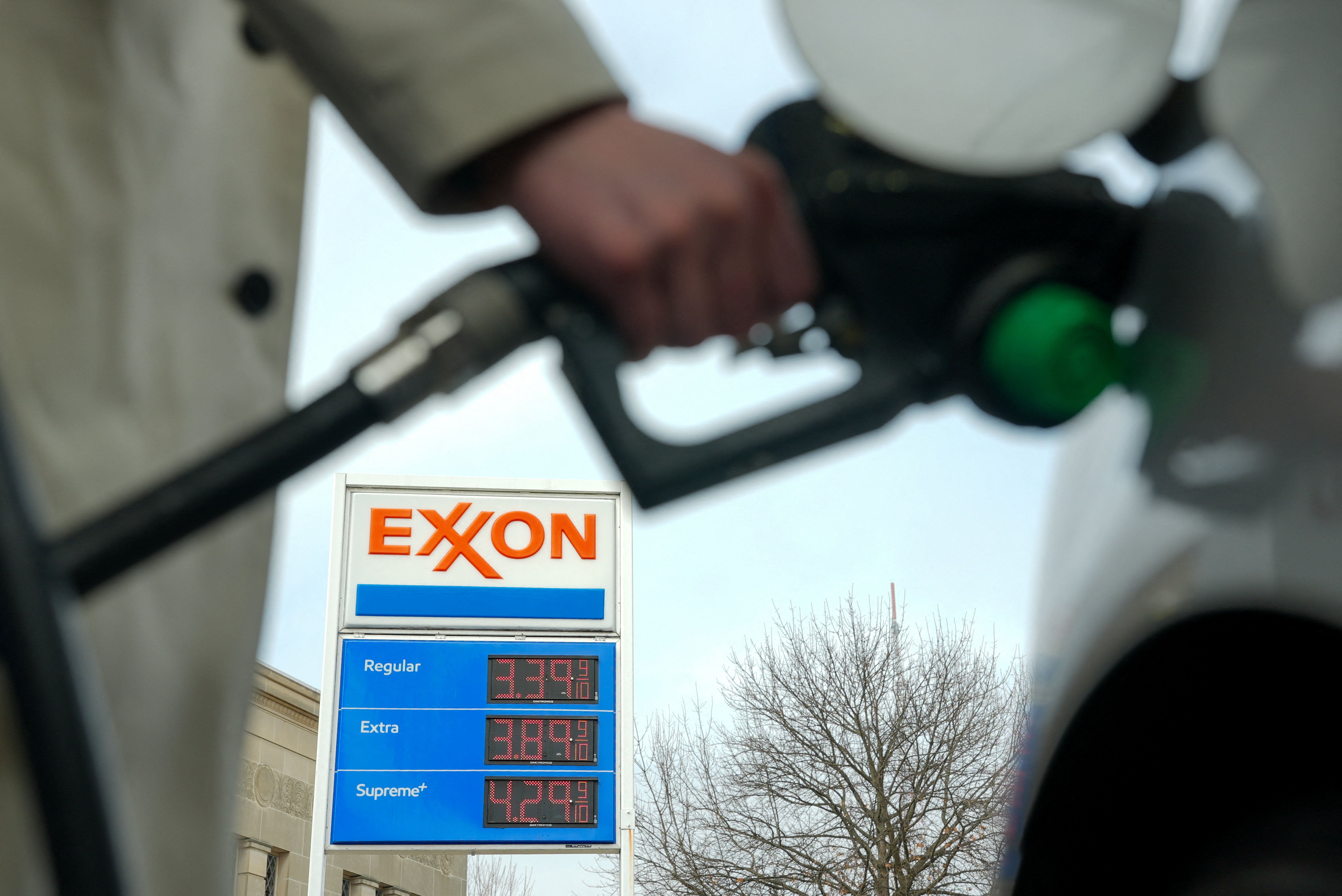 A man pumps gas at an Exxon station as the price of oil and gas has surged.