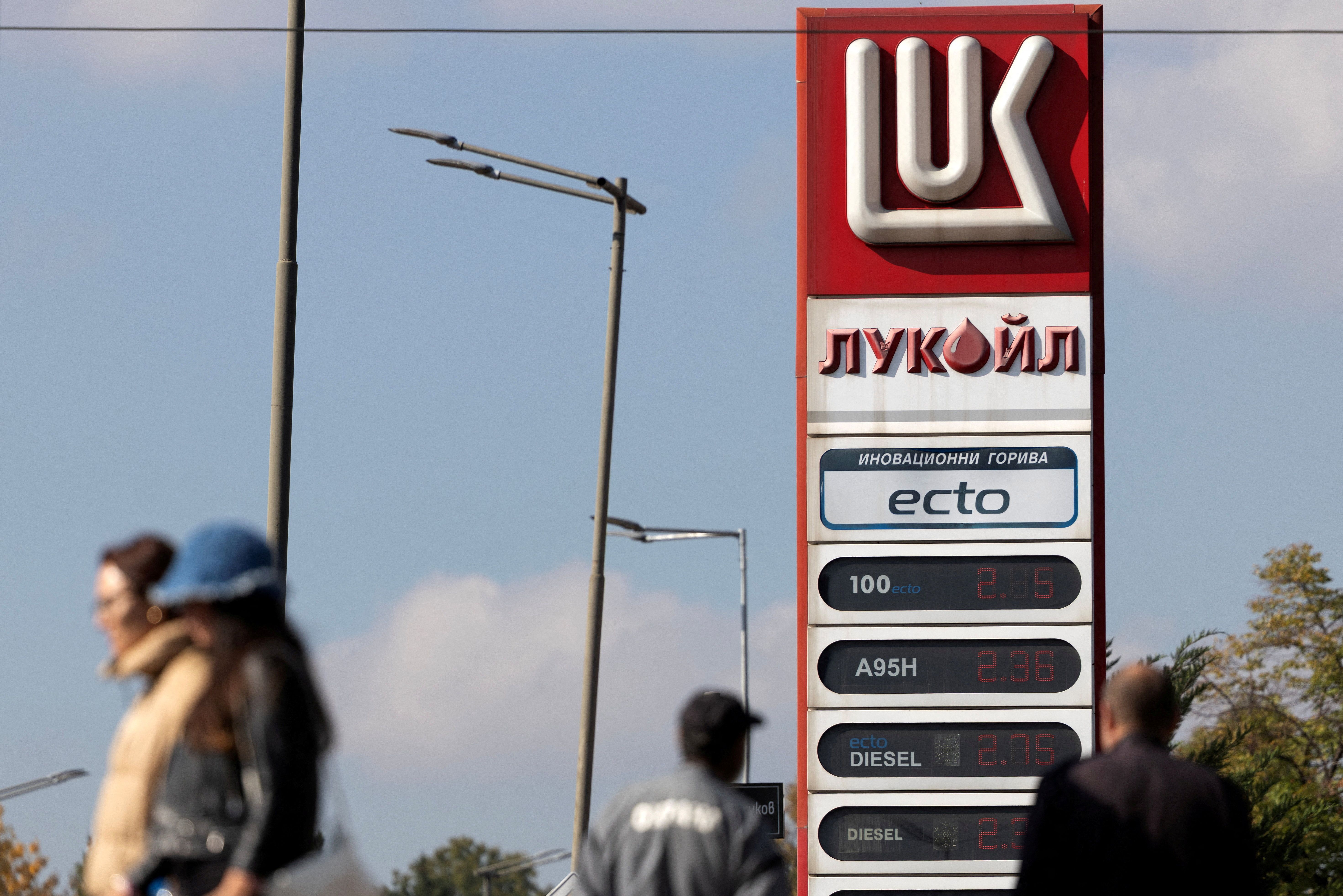 People walk near a Lukoil gas station in Sofia