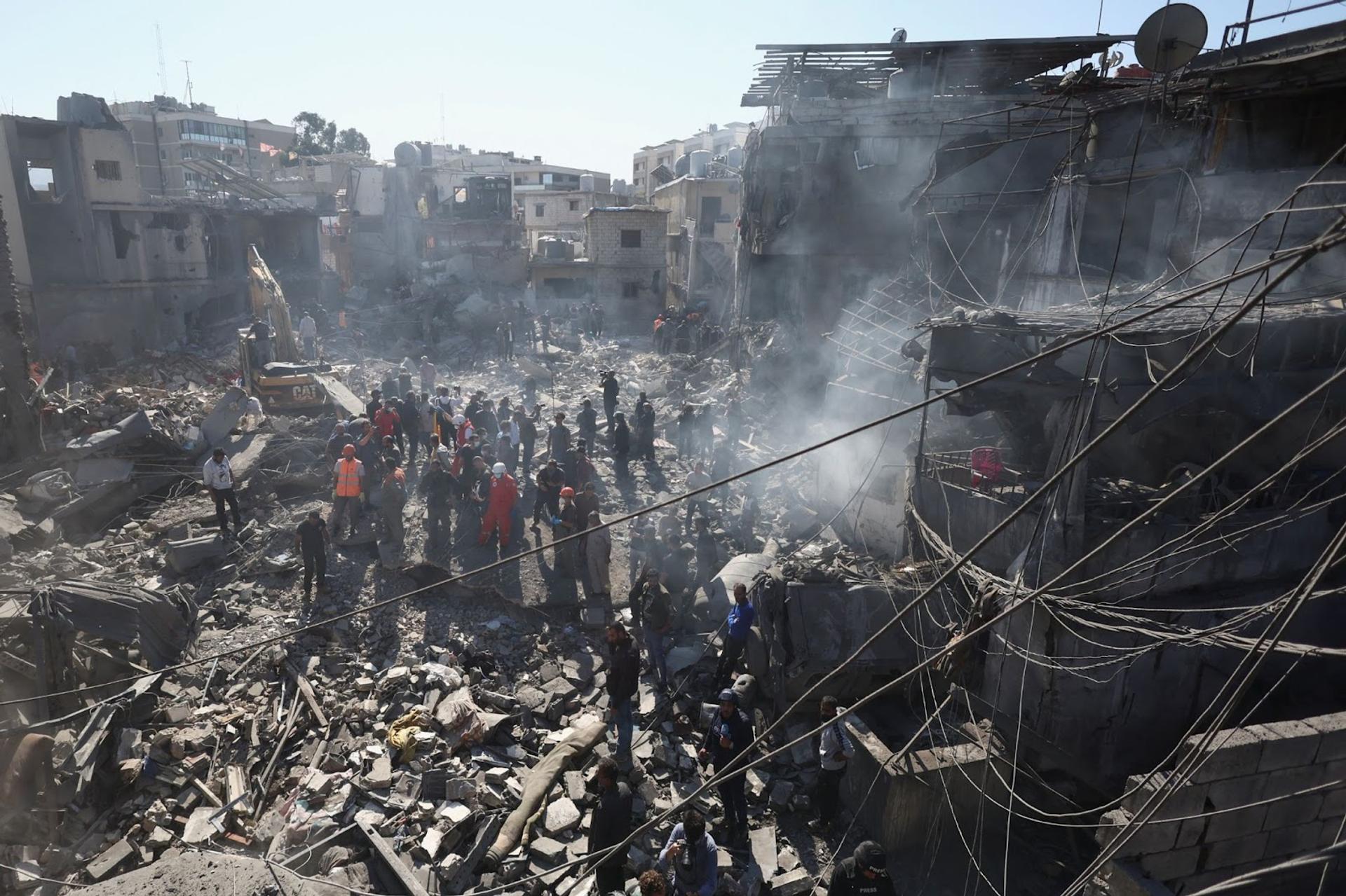 People inspect the damage at the site of an Israeli strike near Rafik Hariri University Hospital.