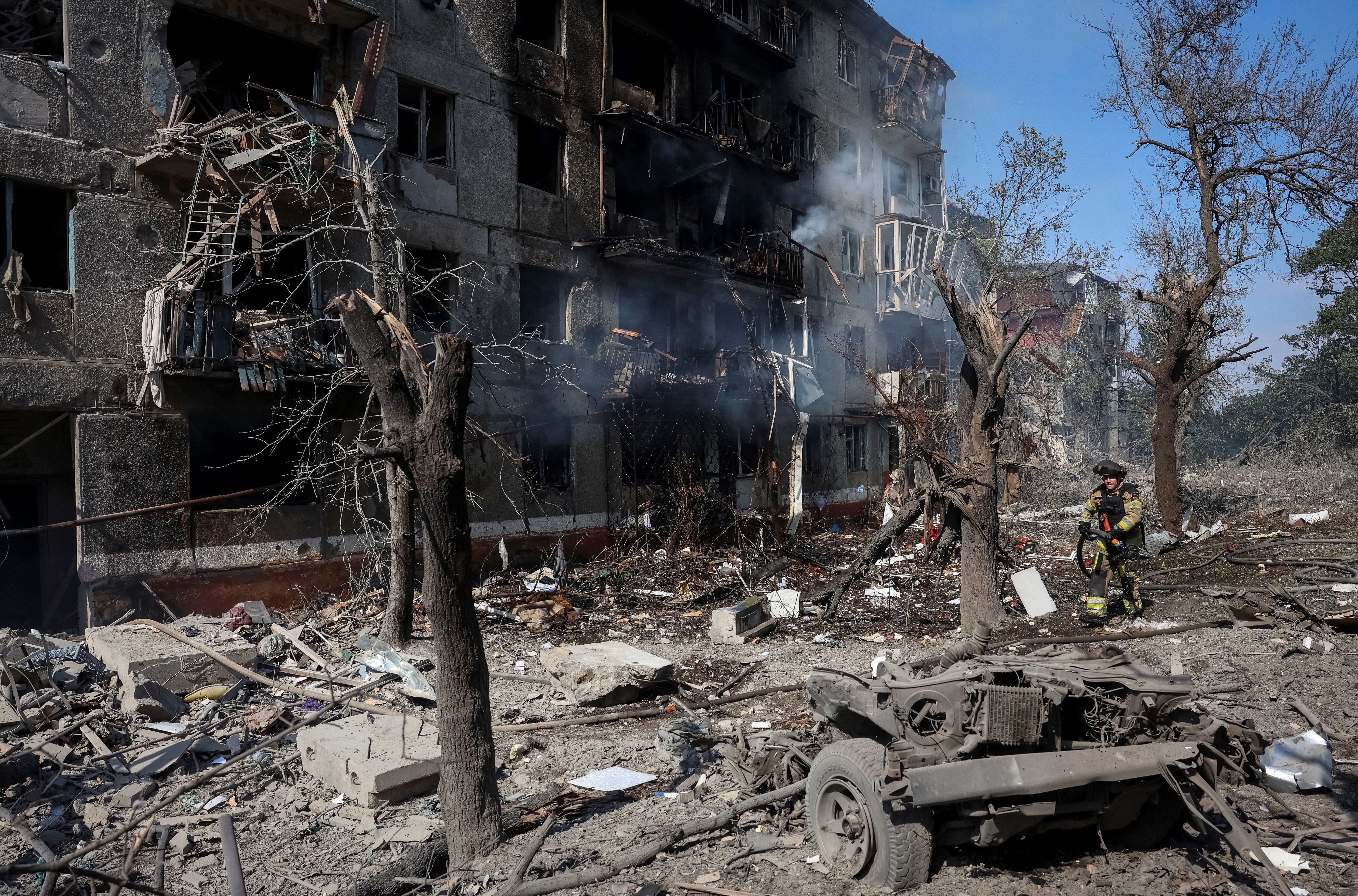 A rescuer works at a site of an apartment building damaged during a Russian air strike, amid Russia’s attack on Ukraine