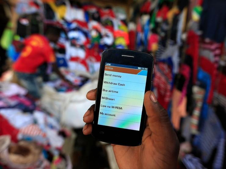 A man holds up his mobile phone showing a M-Pesa mobile money transaction page in Kenya’s capital Nairobi on Dec. 31, 2014.