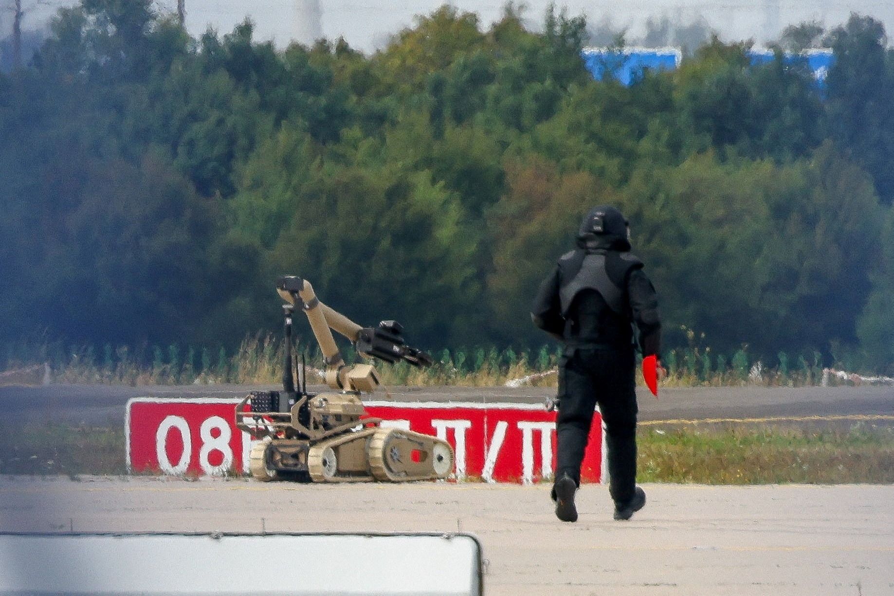 A police officer walks towards an explosive-disarming robot at Leipzig /Halle Airport. 