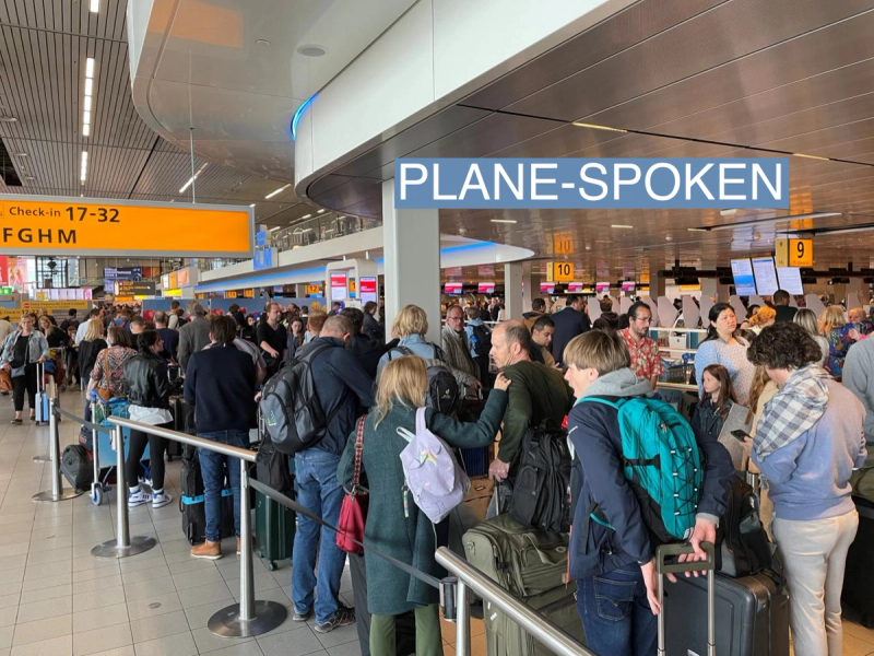 Travellers wait in lines at Amsterdam Schiphol Airport.