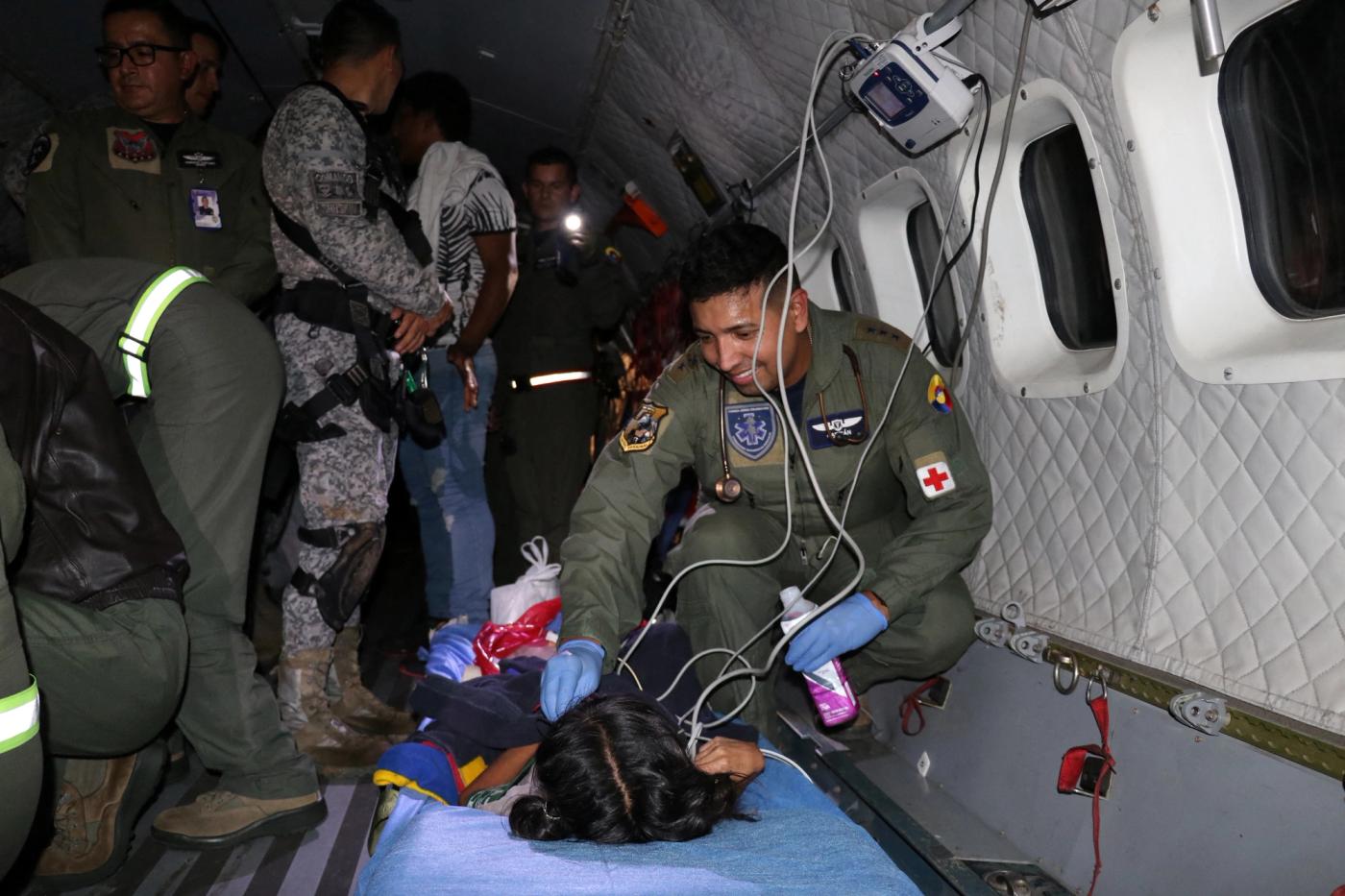 Soldiers of the Colombian Air Force agive medical attention inside a plane to the surviving children of a plane crash in the thick jungle.