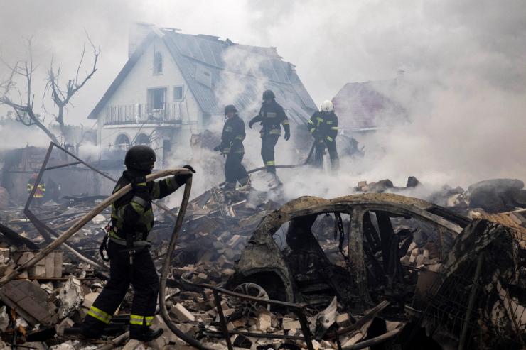 Emergency workers extinguish fire in the debris of a private house that was destroyed in a Russian rocket strike in Markhalivka, Kyiv region.