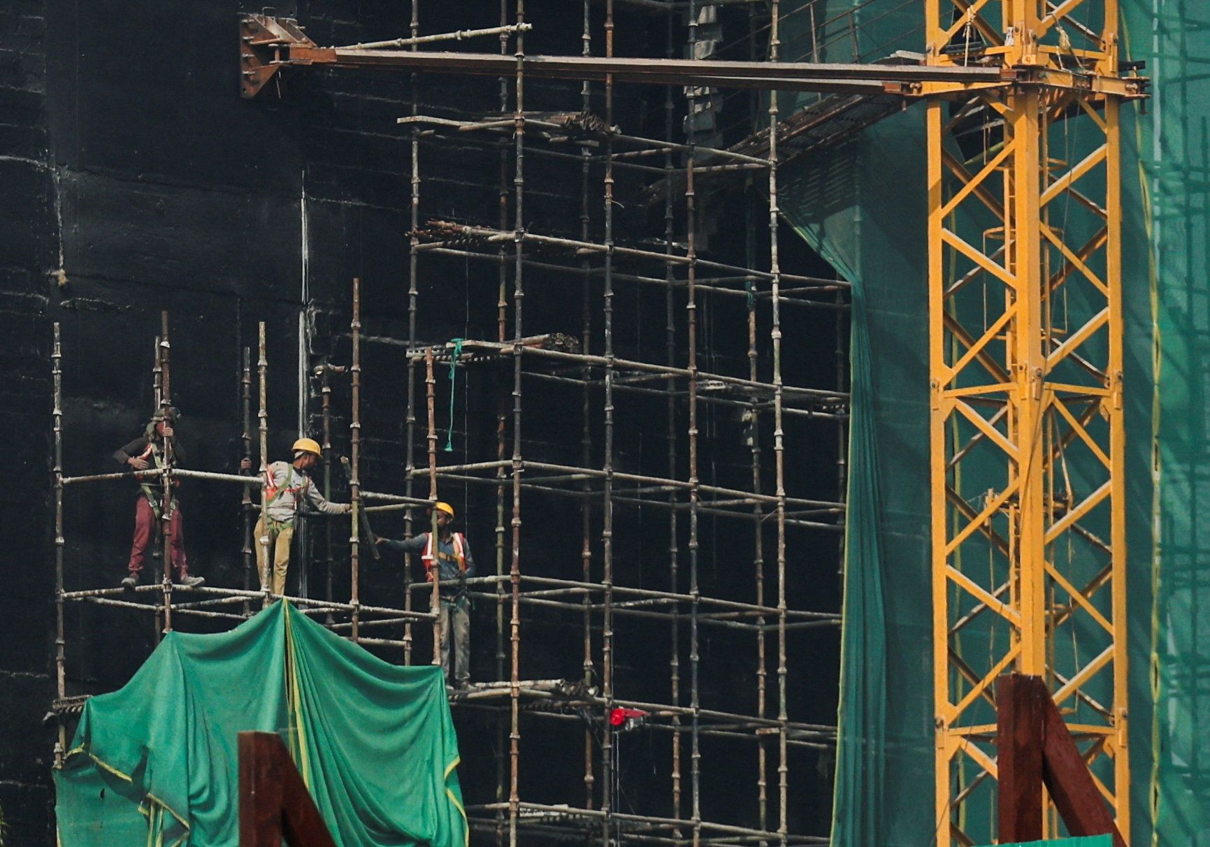 Laborers work on a building near Kartavya Path in New Delhi, India