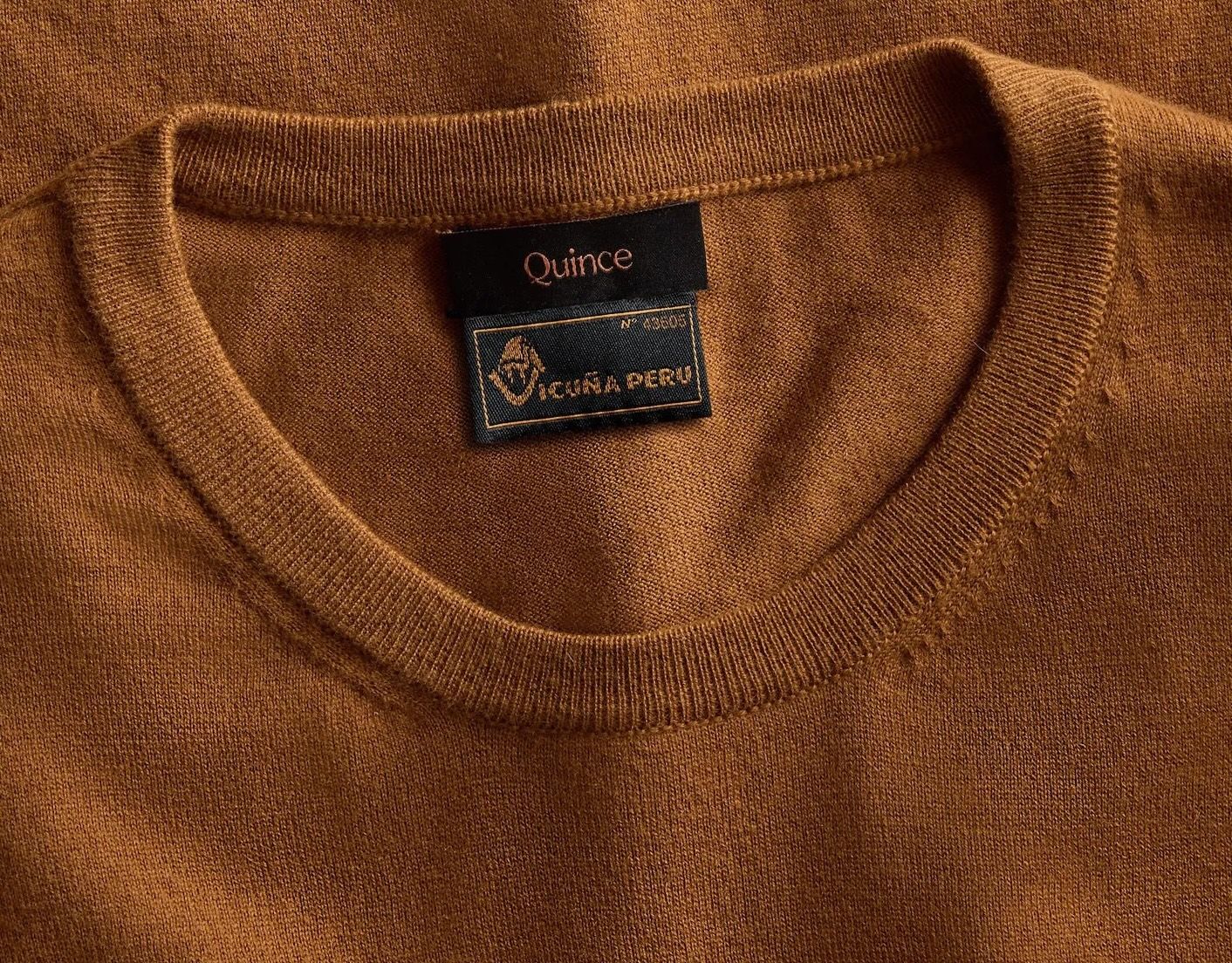 A sweater with a Quince logo.