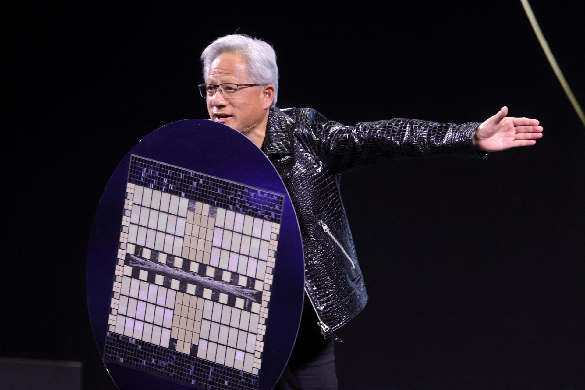 Nvidia CEO Jensen Huang holds a shield designed to look like a computer chip.