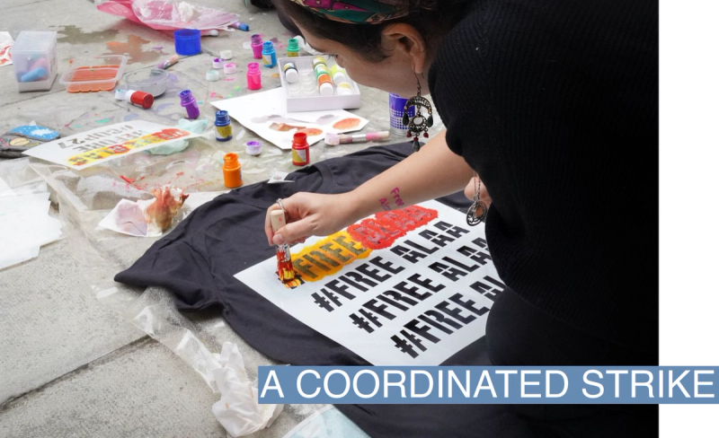Alaa Abdel-Fattah's sister stencils a t-shirt during a protest in solidarity with Alaa outside the British Foreign Office on October 30, 2022.