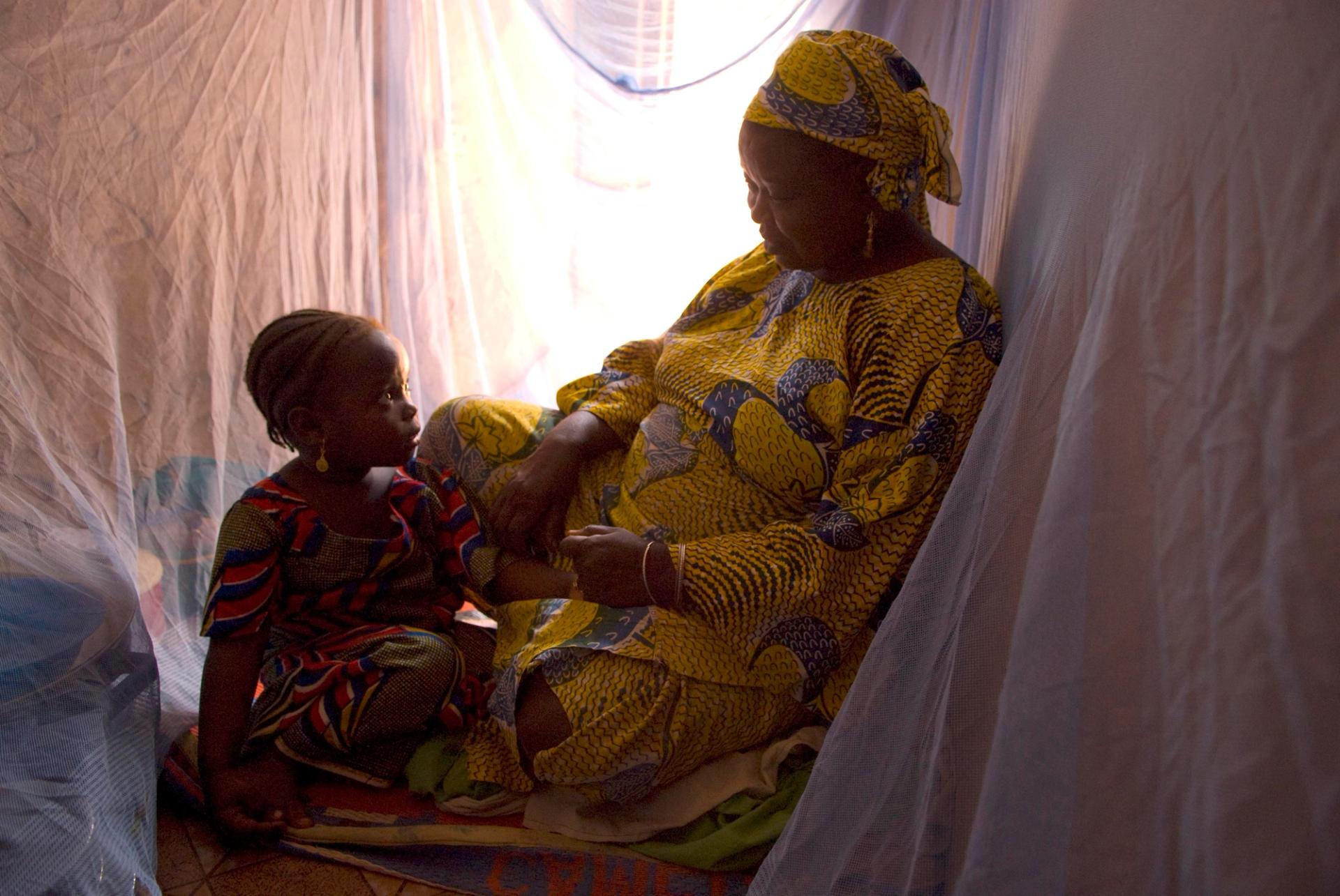 A family rests under a protective mosquito net in Nigeria