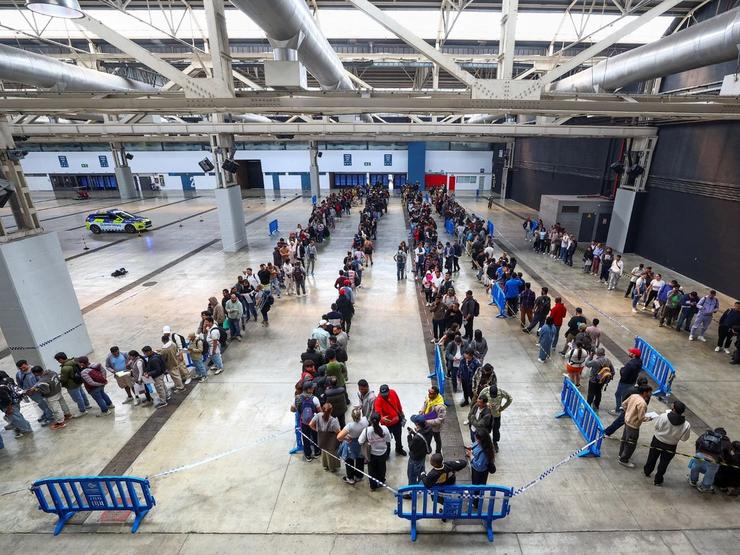 Migrants queue at a Spanish airport