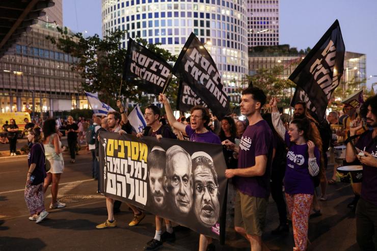 Demonstrators hold a banner featuring images of Israeli Prime Minister Benjamin Netanyahu, Finance Minister Bezalel Smotrich and National Security Minister Itamar Ben-Gvir.