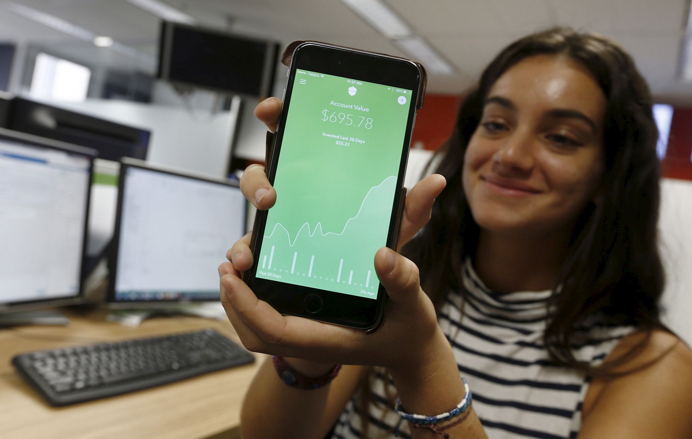 Madison Lucas, an employee of U.S.-based technology company Acorns, demonstrates their smartphone-based app