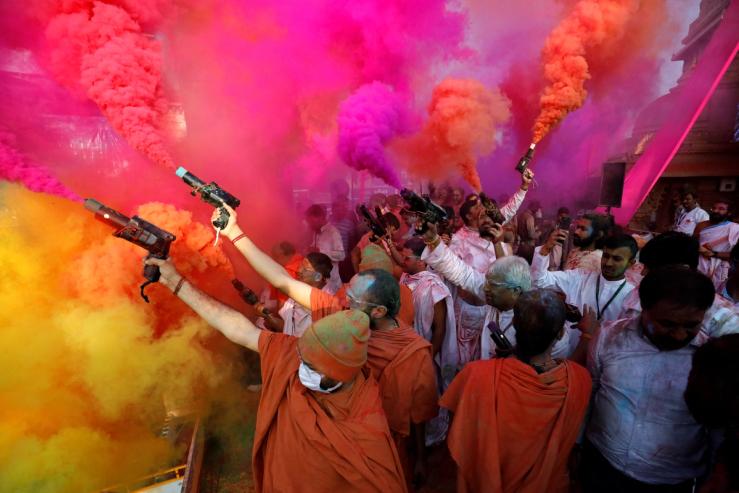 Hindu priests use colour smoke guns to celebrate Holi, the festival of colours, at a temple premises in Salangpur, in the western state of Gujarat, India, March 7, 2023. REUTERS/Amit Dave