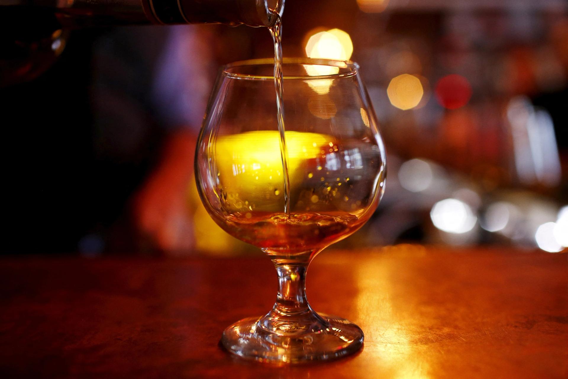 A glass of cognac is pictured on a bar