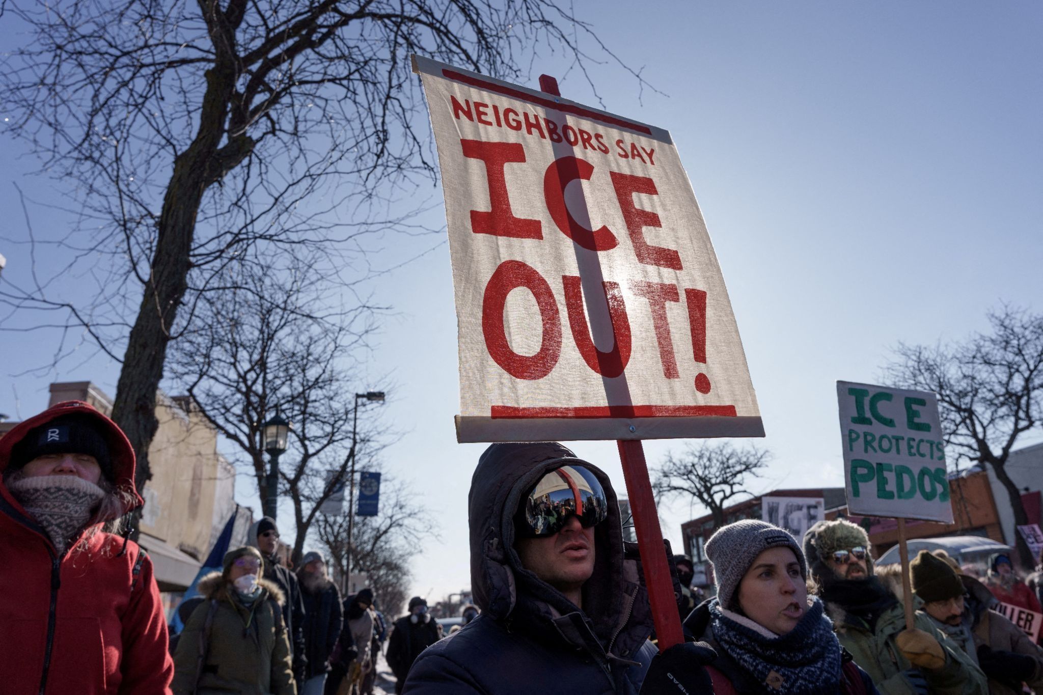 Demonstrators carry signs condemning Immigration and Customs Enforcement (ICE) near the site where Alex Pretti was fatally shot by federal agents 