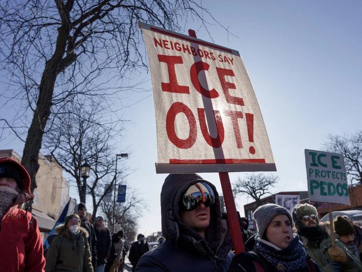 Demonstrators carry signs condemning Immigration and Customs Enforcement (ICE) near the site where Alex Pretti was fatally shot by federal agents