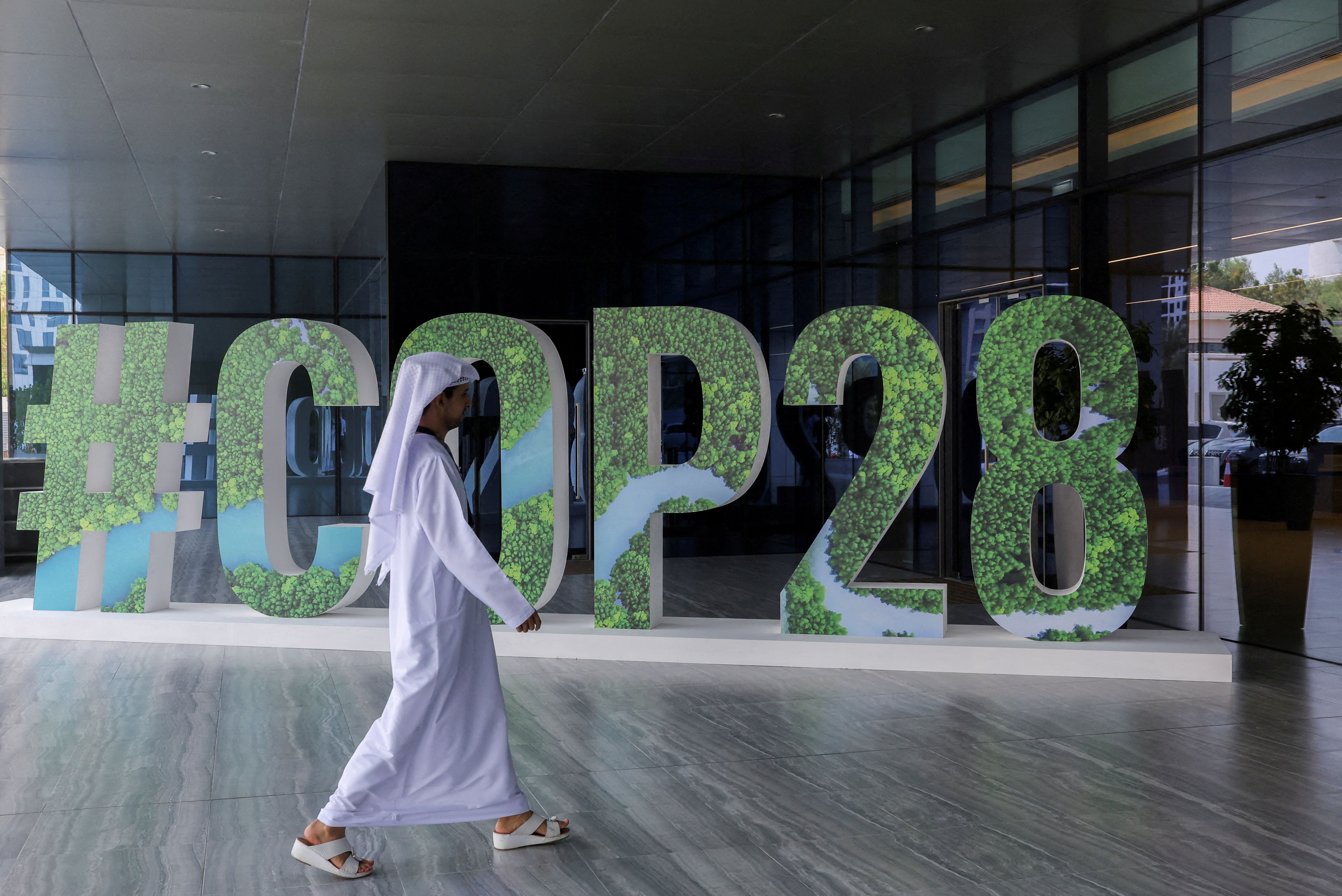 A person walks past a “#COP28” sign in Abu Dhabi, United Arab Emirates, October 1, 2023. REUTERS/Amr Alfiky/File Photo