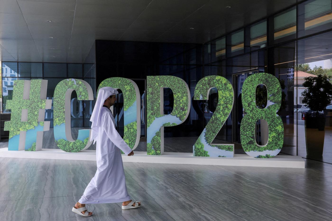 A person walks past a "#COP28" sign in Abu Dhabi, United Arab Emirates, October 1, 2023. REUTERS/Amr Alfiky/File Photo