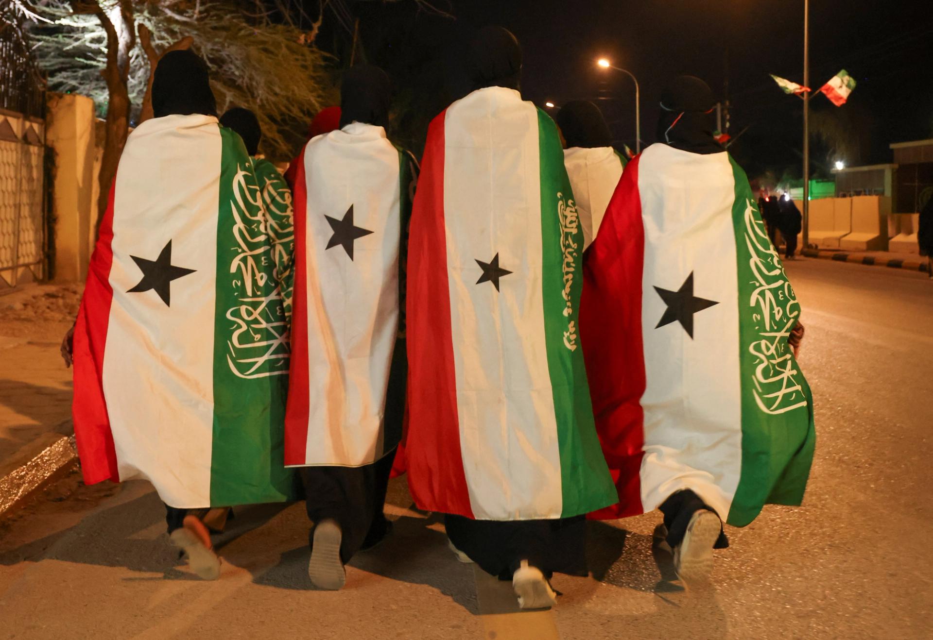 Members of the Hargeisa Basketball Girls team wrapped in the Somaliland flags walk on Road Number One during the Independence Day Eve celebrations in Hargeisa, Somaliland.