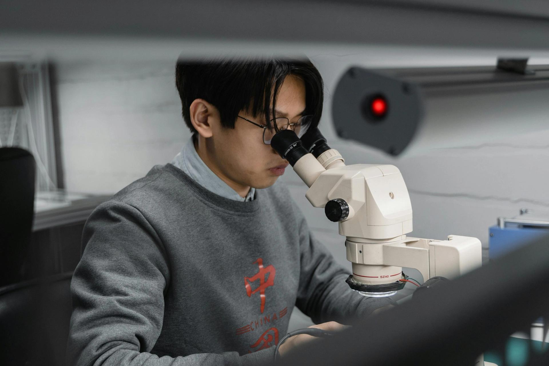 Man looks into a microscope.