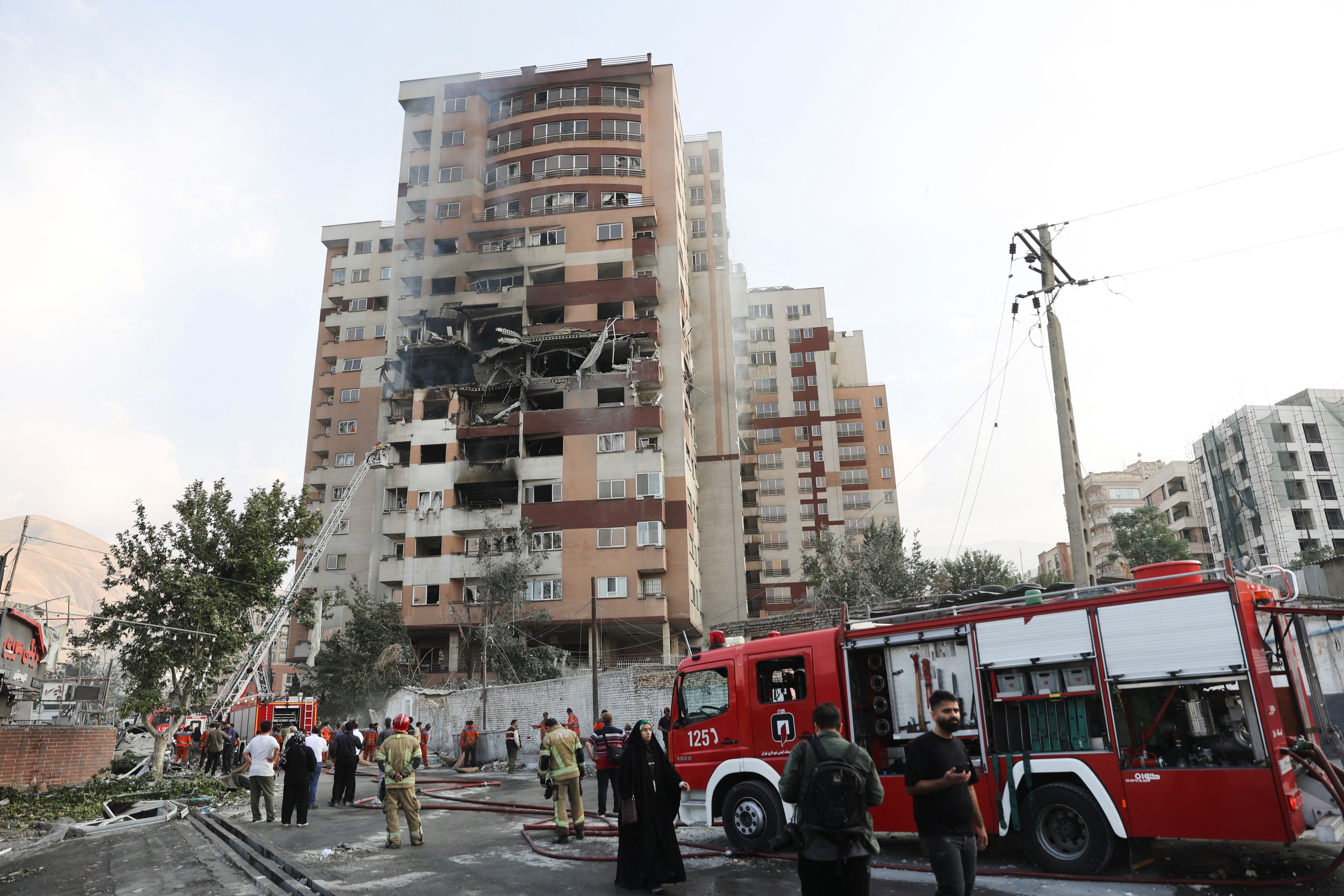 Firefighters work at the scene of a damaged building.