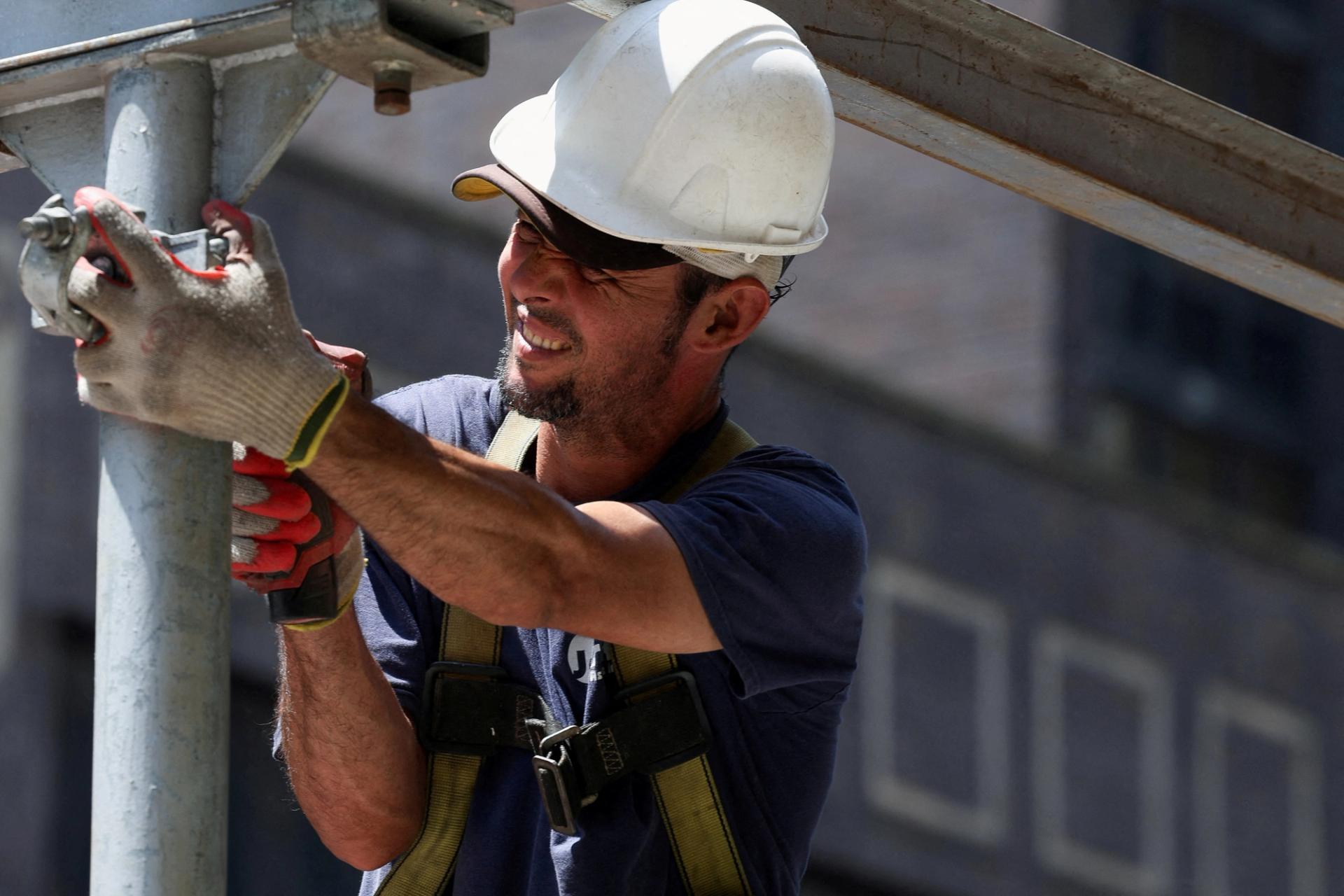 A construction worker uses a drill in New York City on July 17, 2024