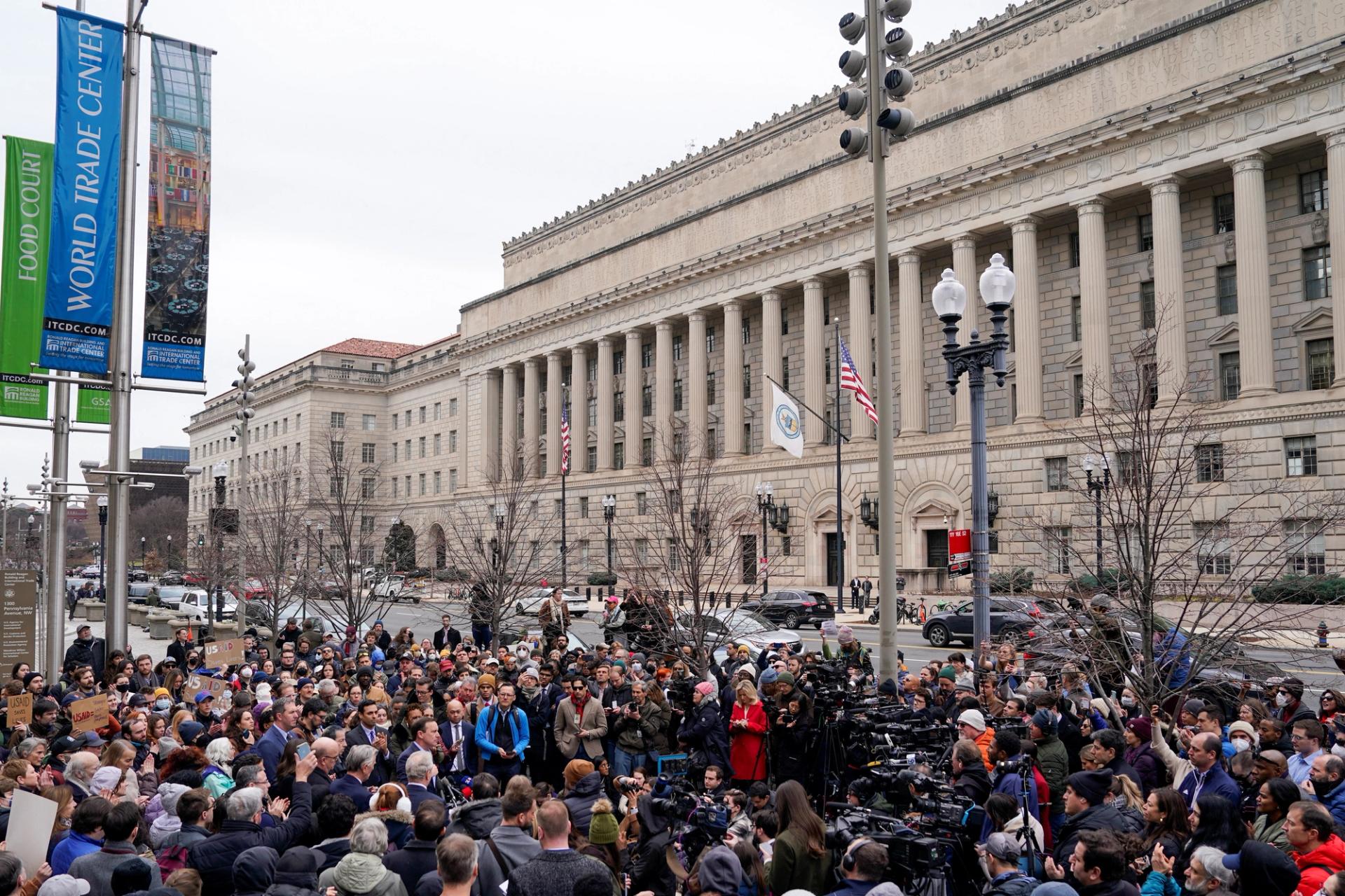 People gather around the USAID building in Washington, DC