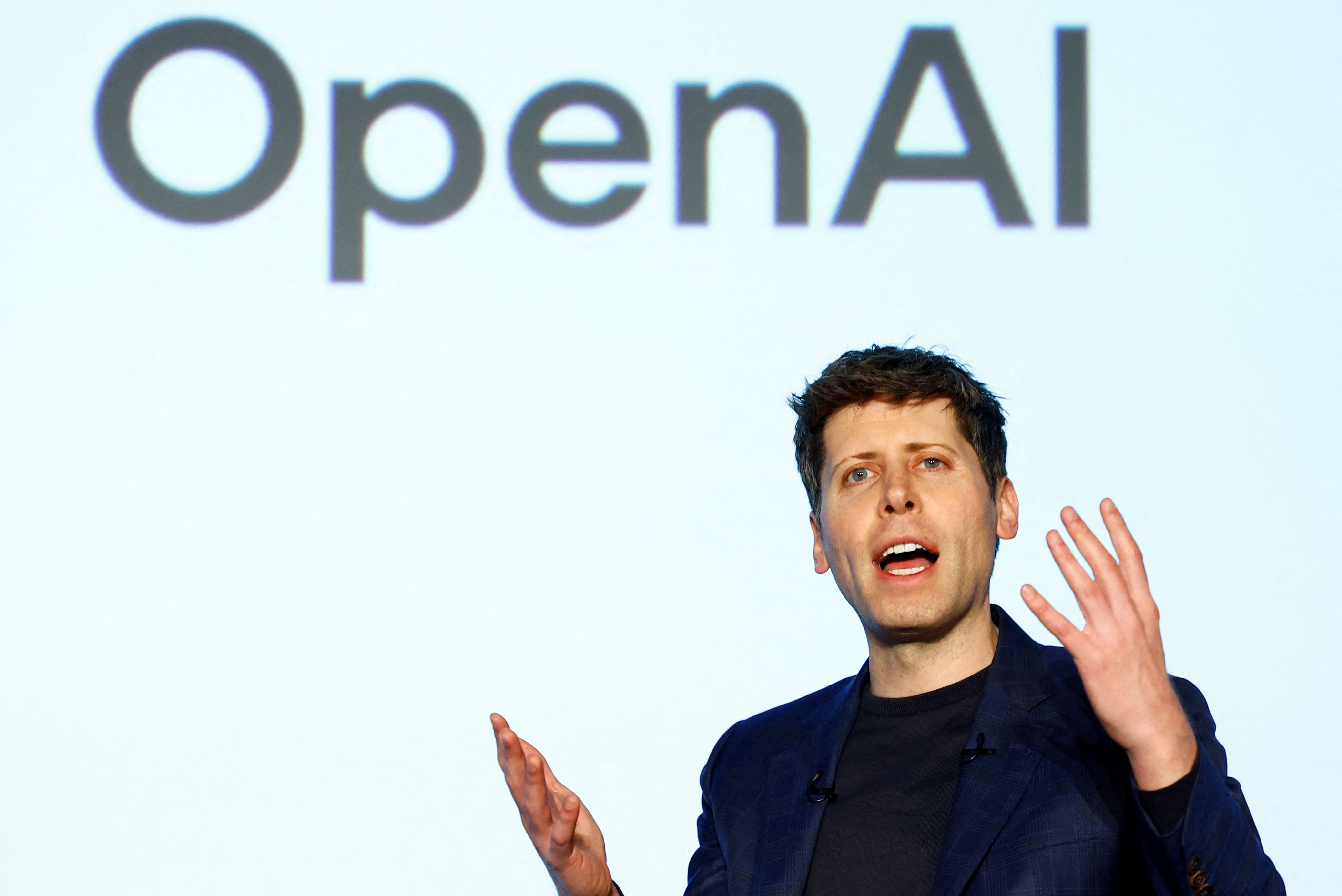 OpenAI CEO Sam Altman in front of an OpenAI logo