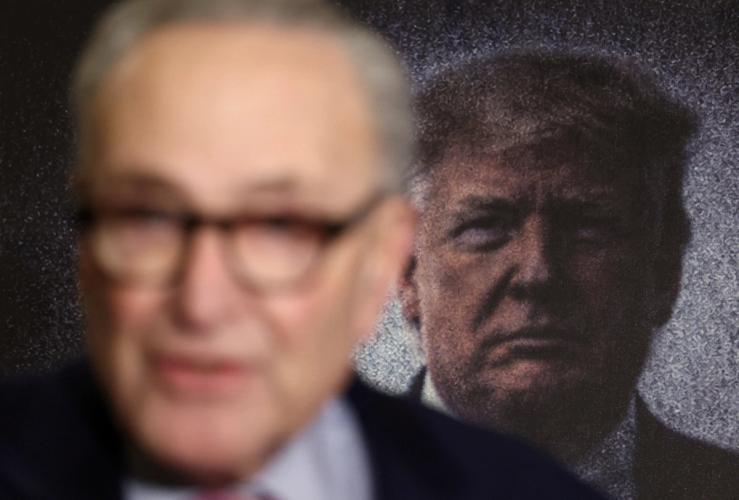 Chuck Schumer with Donald Trump in the background