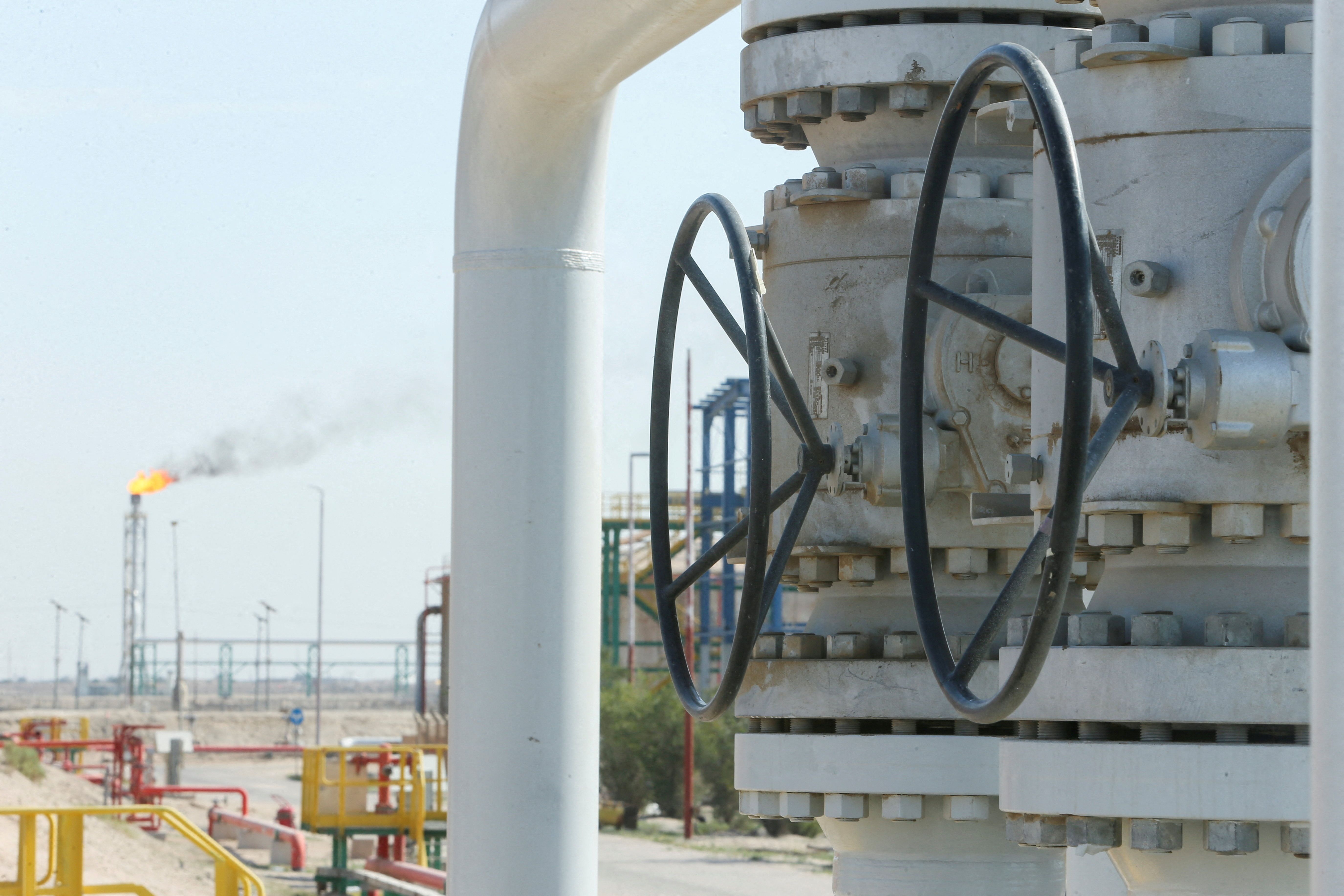 A gas flare burns in the distance at the Rumaila oil field, Iraq.