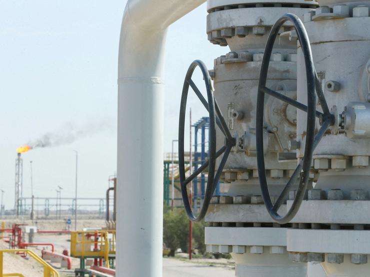 A gas flare burns in the distance at the Rumaila oil field, Iraq.