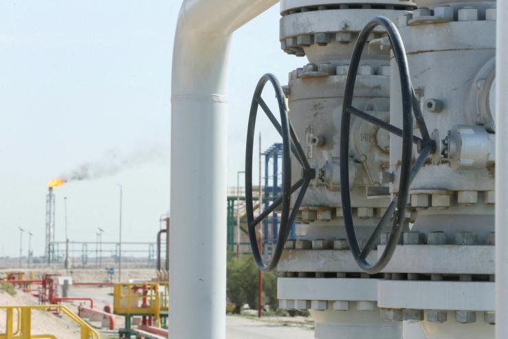 A gas flare burns in the distance at the Rumaila oil field, Iraq.