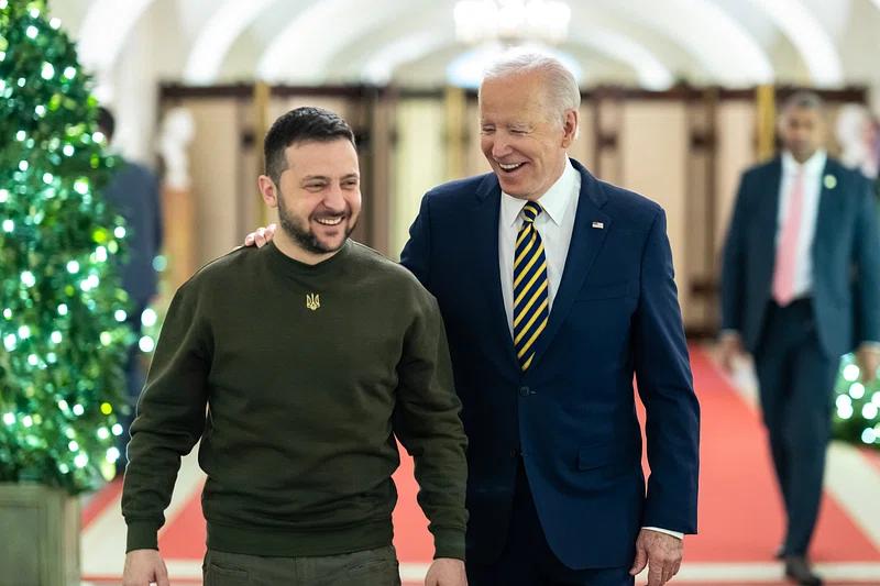 President Joe Biden pictured smiling while walking with Volodymyr Zelenskyy