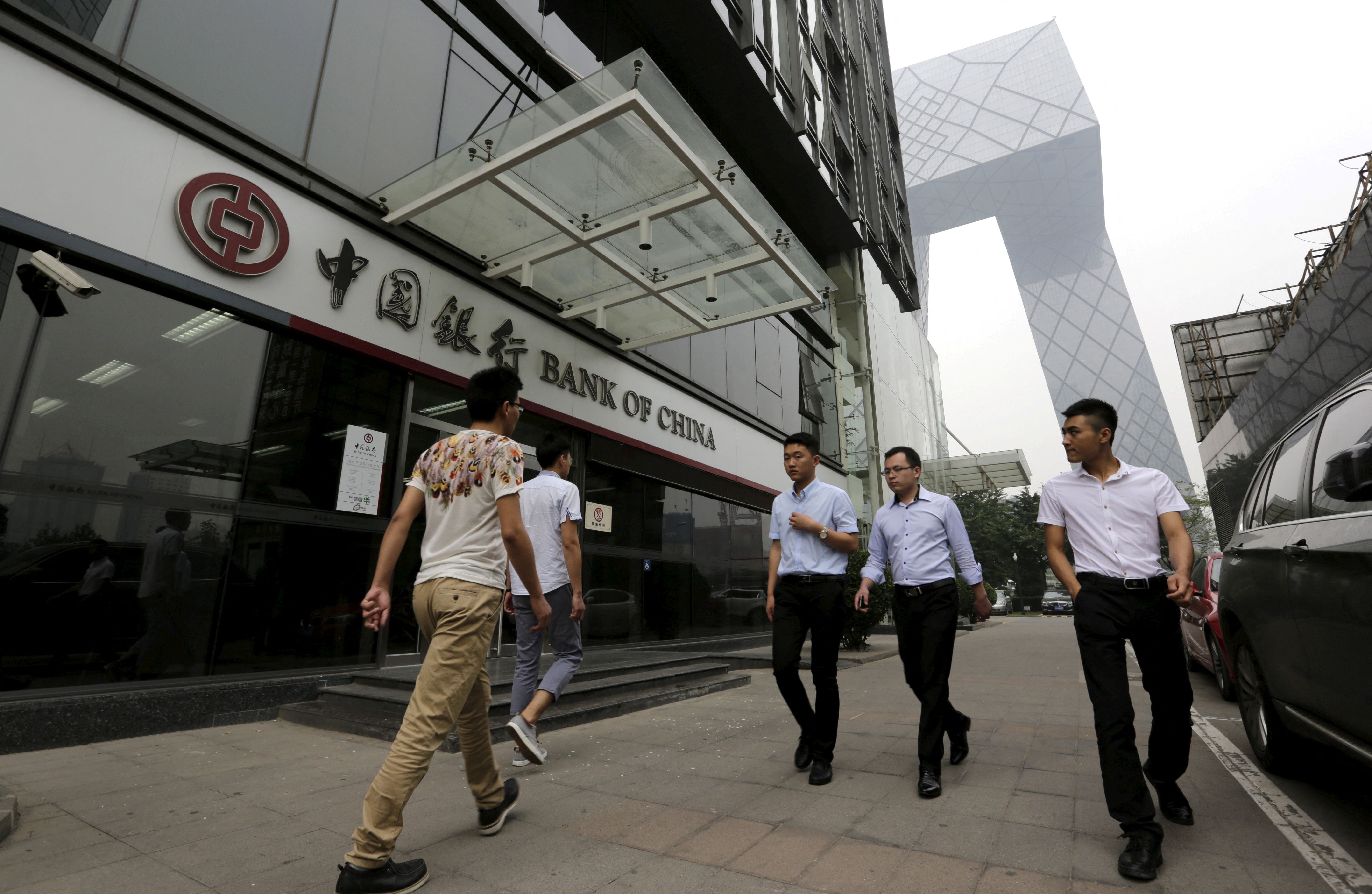 Pedestrians walks past a branch of Bank of Beijing in China. 