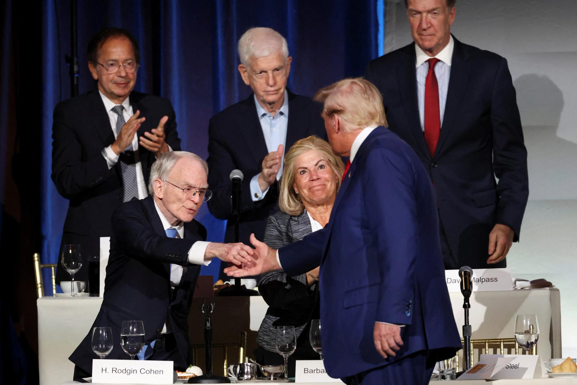 Donald Trump shakes hands with Senior chairman of Sullivan & Cromwell H. Rodgin Cohen at the Economic Club of New York in September 2024.