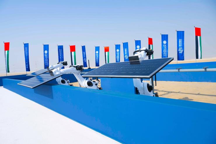 Robotic arms lift the first solar panels at Masdar’s 24/7 solar-and-battery park in Abu Dhabi, UAE on Oct. 23, 2025.