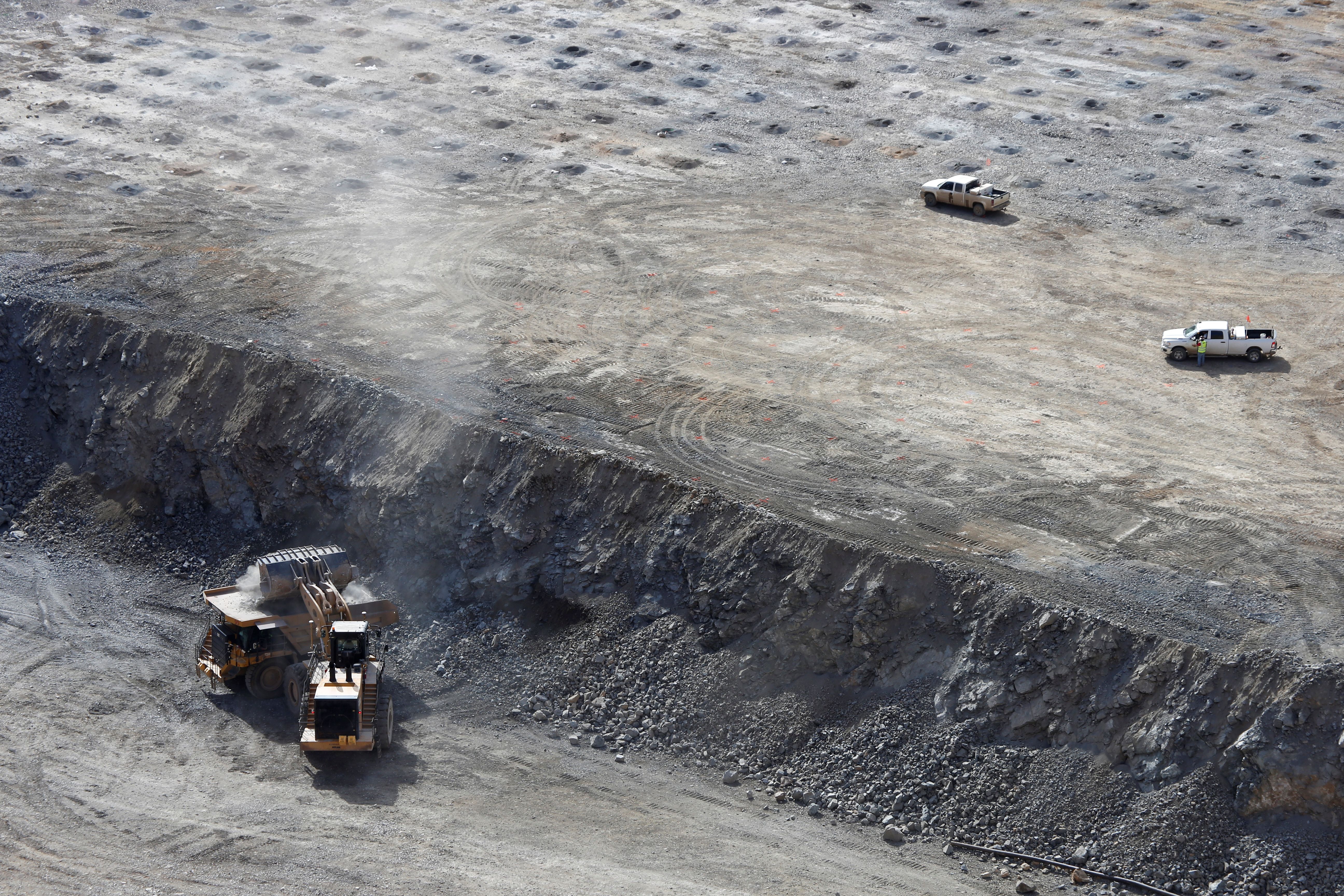 A wheel loader operator fills a truck with ore at the MP Materials rare earth mine in Mountain Pass, California