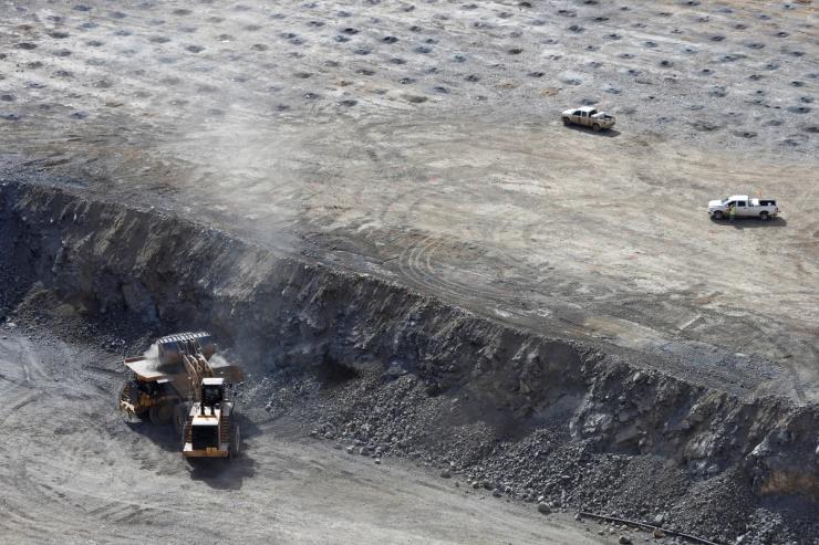 A wheel loader operator fills a truck with ore at the MP Materials rare earth mine in Mountain Pass, California