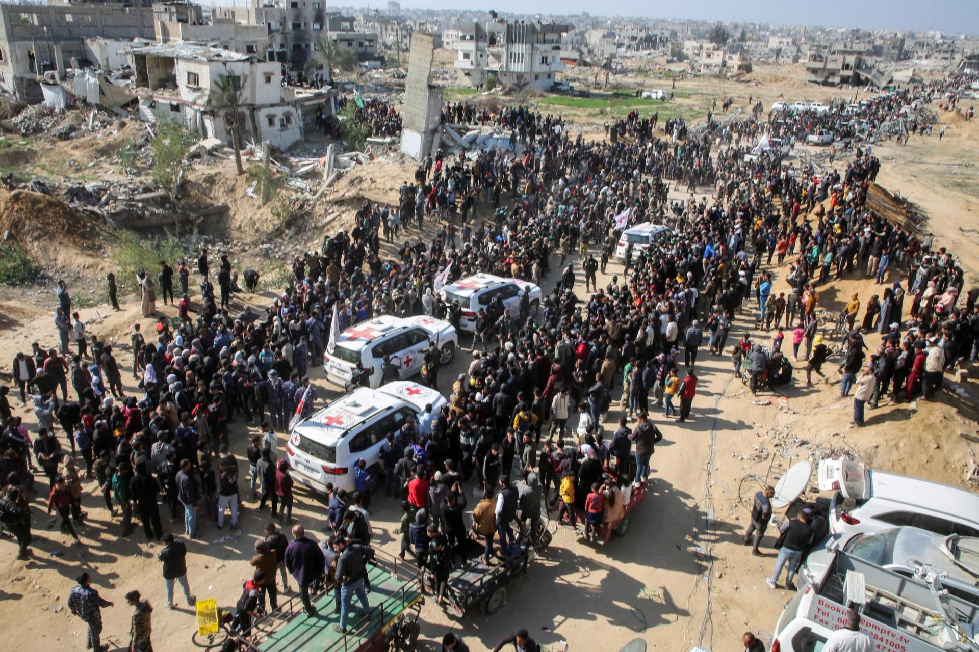 People surround the vehicles of International Committee of the Red Cross (ICRC), on the day of the release of hostages held in Gaza since the deadly October 7 2023 attack, as part of a ceasefire deal in Gaza between Hamas and Israel, in Khan Younis in the southern Gaza Strip, January 30, 2025.