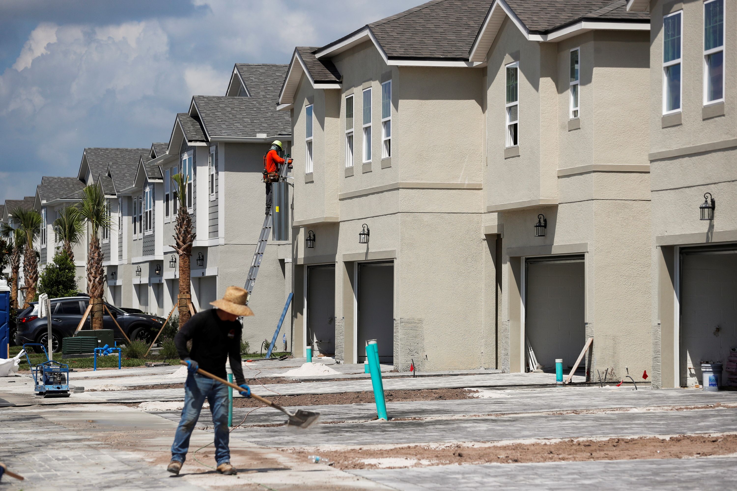 A carpenter works on building new townhomes that are still under construction.