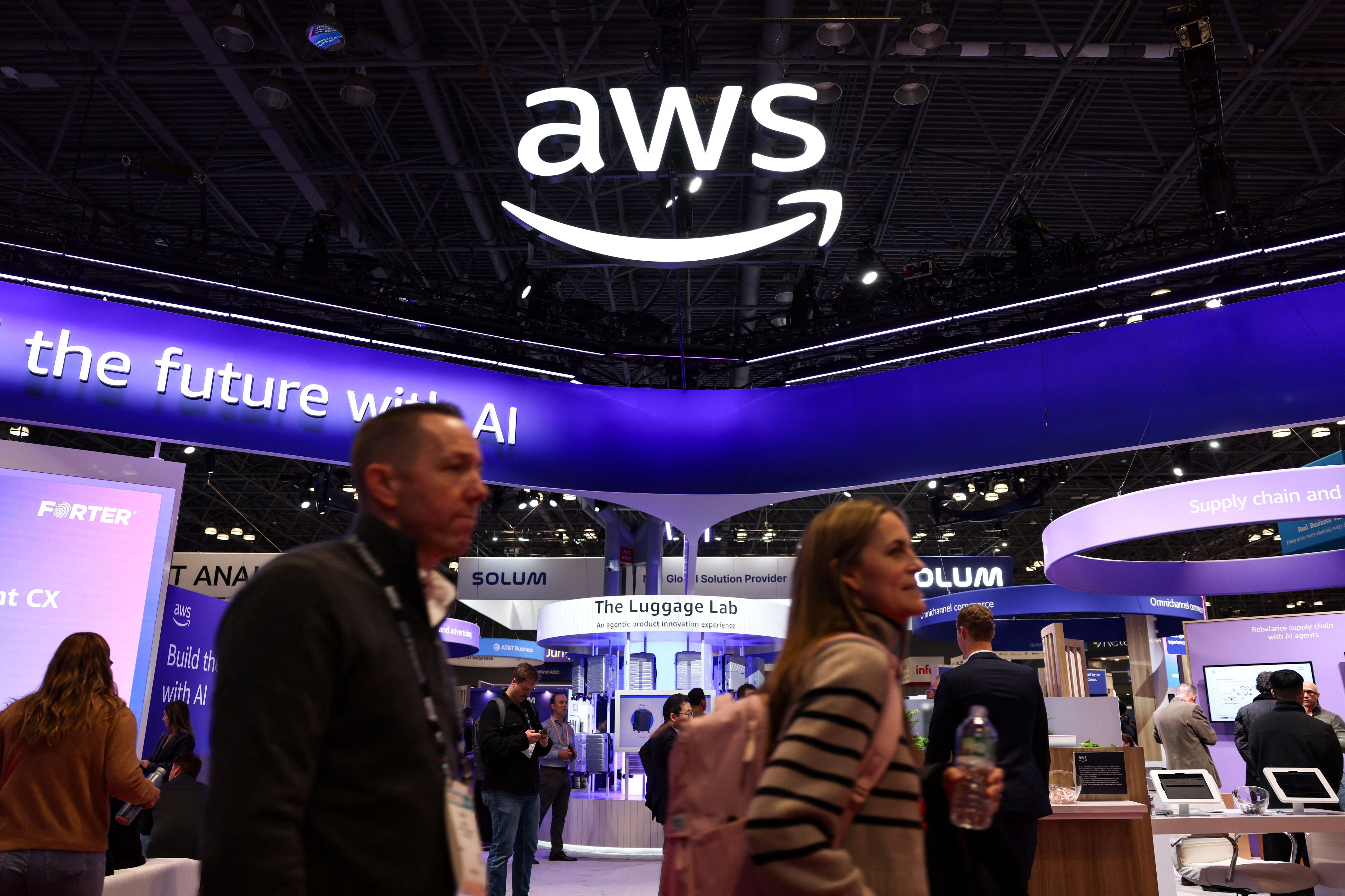 People walk by the exhibit for Amazon Web Services (AWS) at National Retail Federation (NRF) 2026.