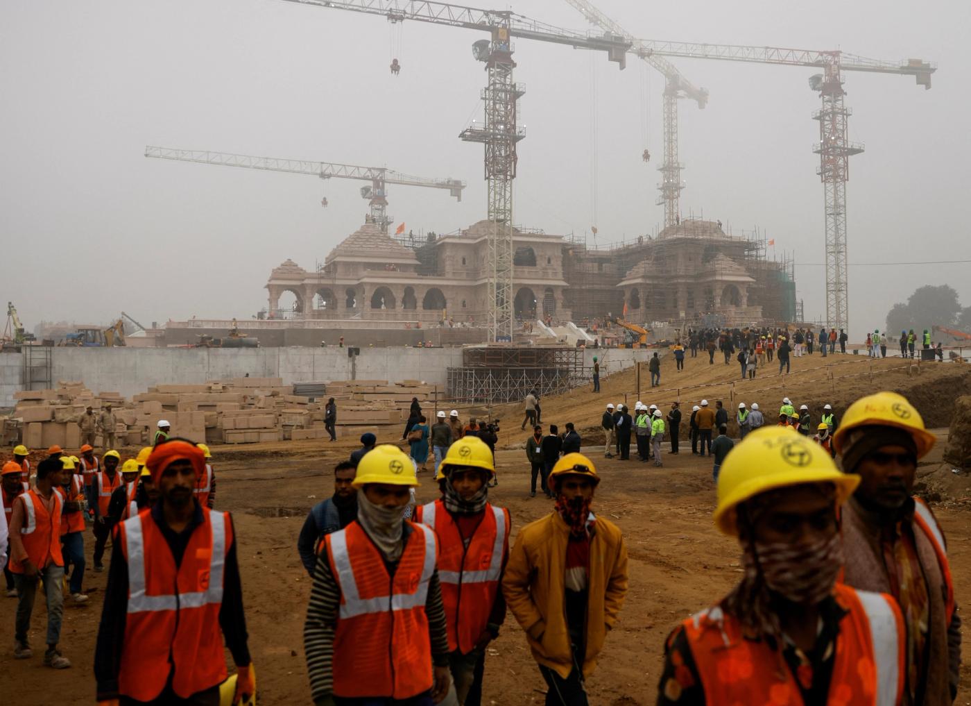 Workers walk in front of the under construction site of the Hindu Ram Temple in Ayodhya, India, December 29, 2023. 