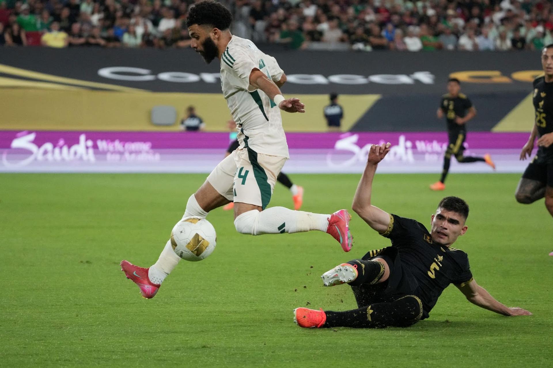 Saudi Arabia forward Abdulrahman Al Obud (24) and Mexico defender Johan Vasquez (5) battle for the ball in the first half during a quarterfinal match of the 2025 Gold Cup at State Farm Stadium. 